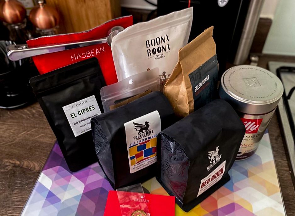 A selection of coffee bean bags, including varieties from Has Bean, Square Mile and Boona Boona, on a kitchen countertop
