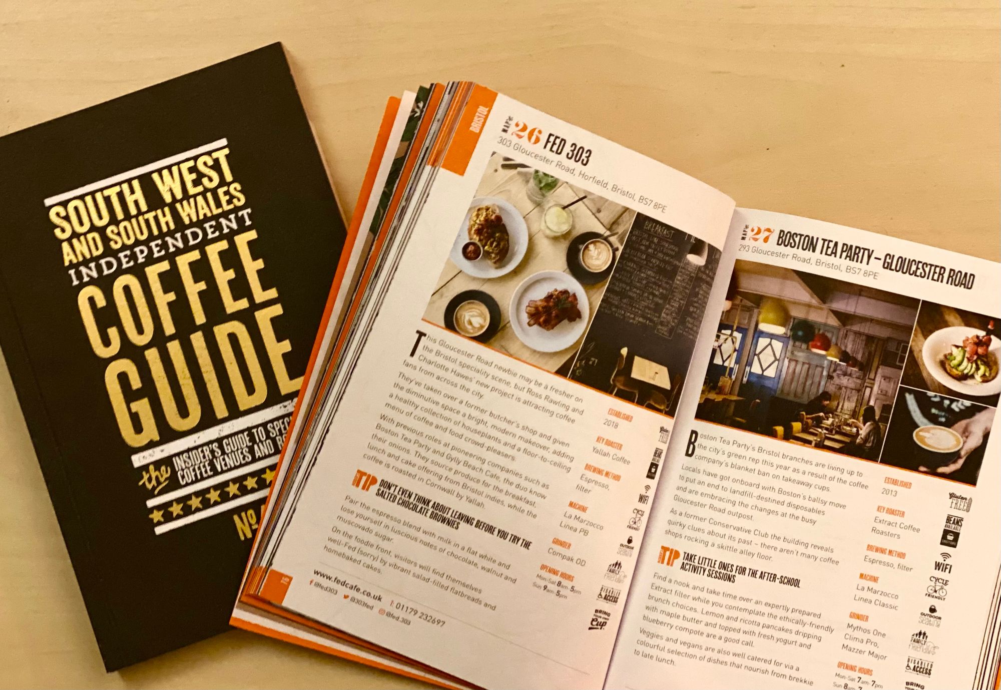 Two copies of the South West and South Wales Independent Coffee Guide, one open and showing a couple of coffee shops